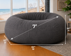 Gray bean bag chair with dimensions labeled in a room with a window view of a beach.